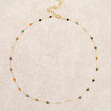 "Aukso Tarpo Karoliukų Kaklo Papuošalas" can be rewritten as "Aukso Tarpo Karoliukų Kaklo Papuošalas" (as it appears to be in Lithuanian). If you're looking for an English translation or a more descriptive title, it could be "Gold Spaced Beaded Necklace."